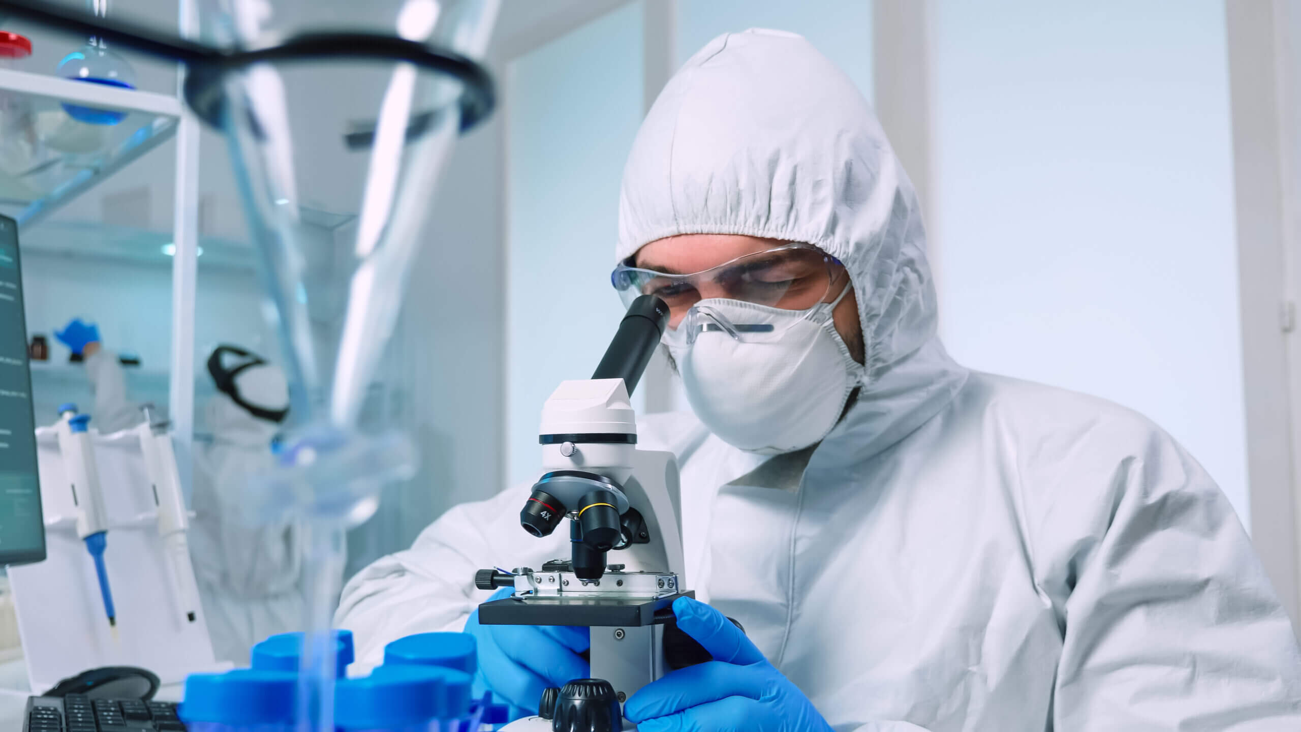 A man looking into the microscope to identify mycoplasma pneumoniae