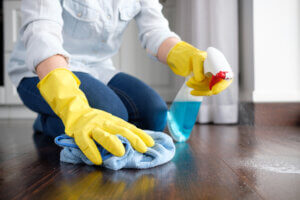 A girl using surface disinfectants to clean the floor