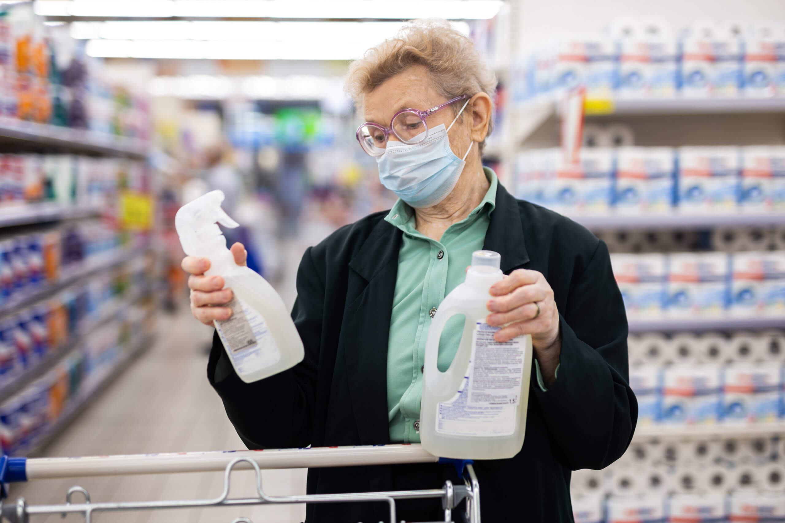 An elderly women checking product labels before purchasing