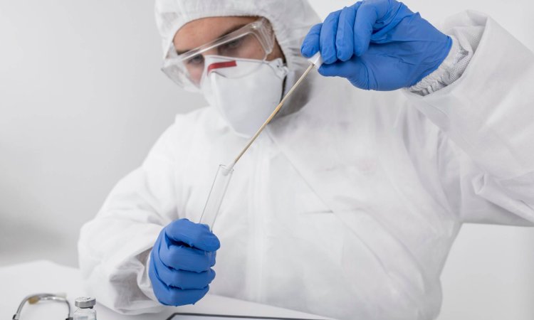 doctor wearing face mask and surgical gloves performing test in a test tube