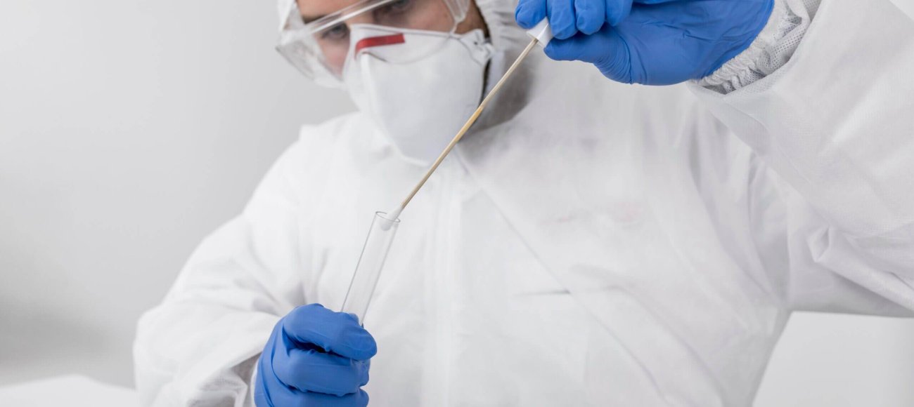 doctor wearing face mask and surgical gloves performing test in a test tube