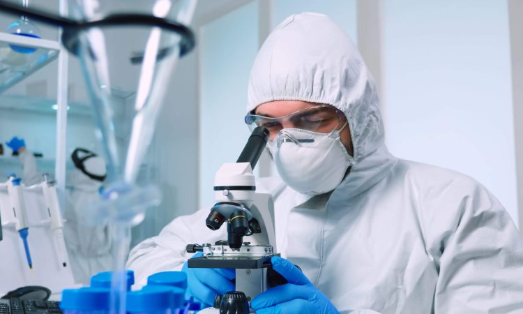 A man looking into the microscope to identify mycoplasma pneumoniae