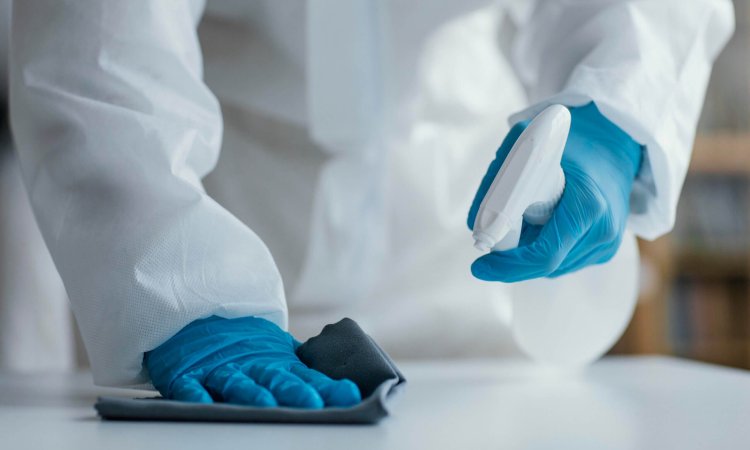 person using disinfectant to clean an area