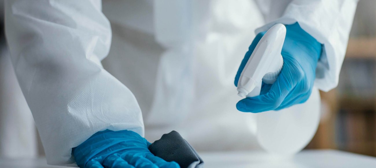 person using disinfectant to clean an area