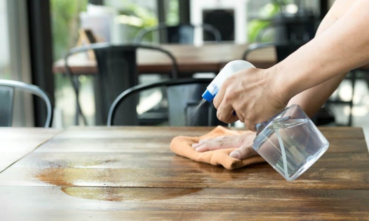 The image depicts the use of EN 14347 certified biocidal products for disinfecting the table