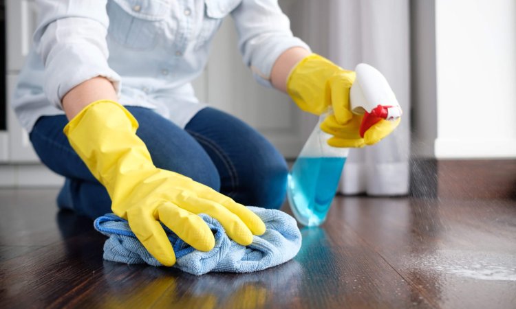 A girl using surface disinfectants to clean the floor