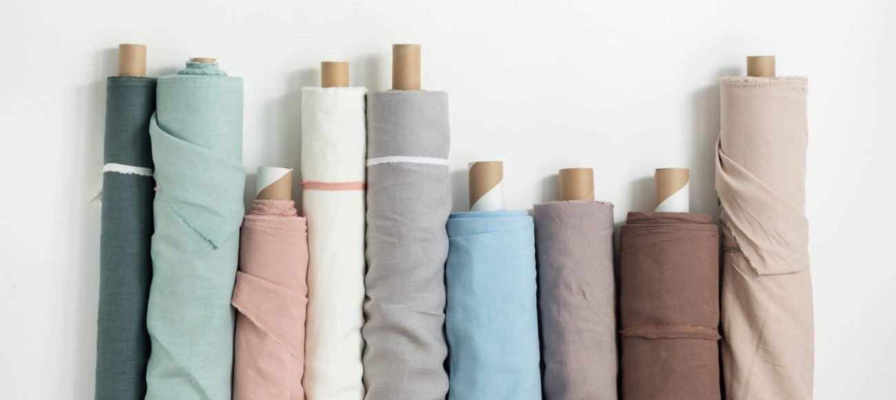 Different,Colors,Fabric,Linen,Rolls,On,The,White,Walls,,Selective