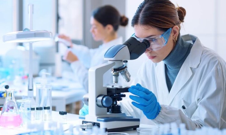 The image describes a lab technician performing biocidal product testing using a microscope to enumerate the viable spores.